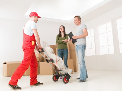 Professional movers carrying furniture for a Twickenham man and van service